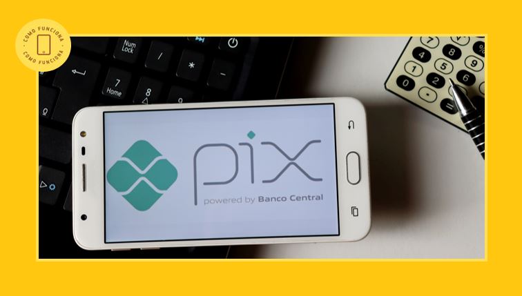 O que é o Pix - Logotipo Pix na tela do smartphone em cima do laptop com calculadora e caneta